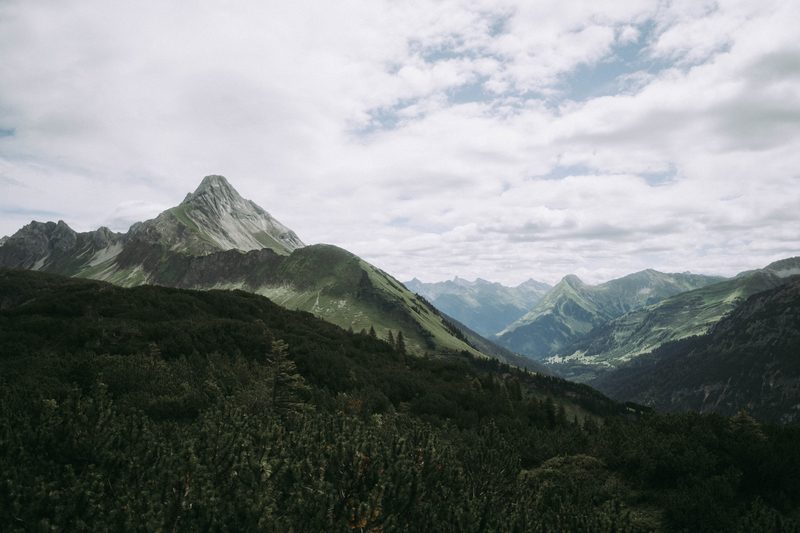 Alpine panorama in the Rappenalp valley — a pointed peak above forested slopes, high Allgäu mountains beyond