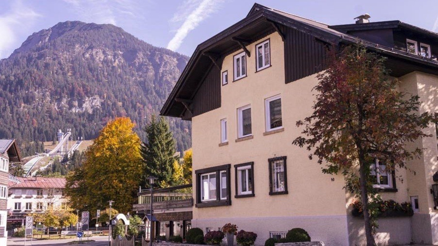 Haus NH40 on Nebelhornstraße 40 in Oberstdorf, with the Schattenberg ski jump and the main ridge behind it.